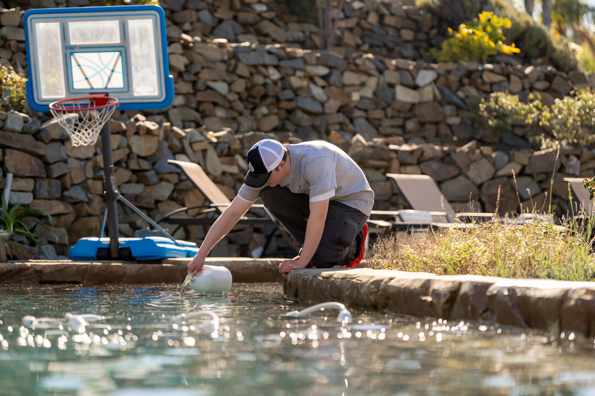Pool Ninja tech adding chemicals to balance pool water