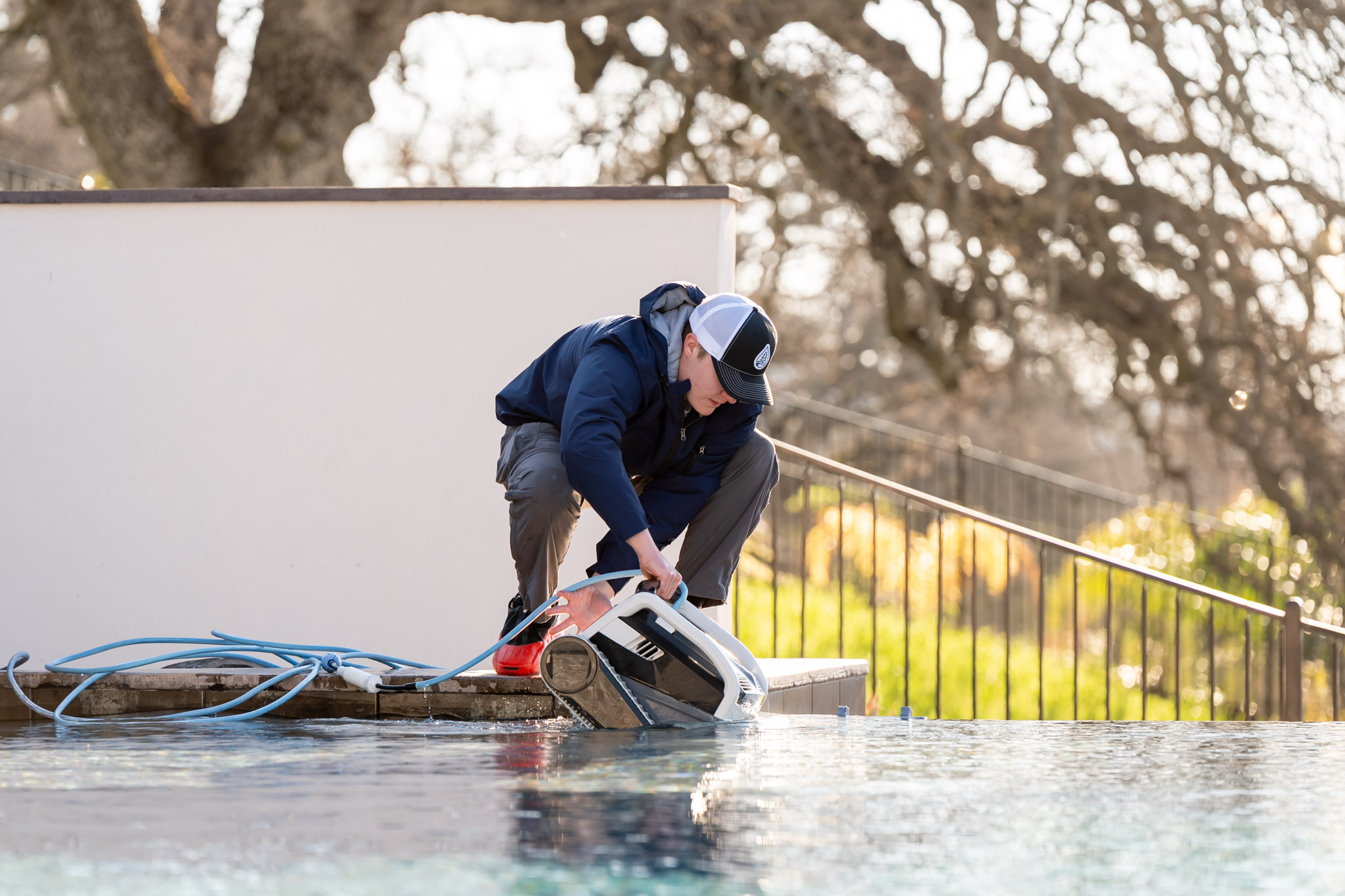 Pool Ninja tech servicing pool equipment with hose